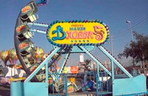 Abuelitos se divierten a bordo de un juego mecánico en la feria